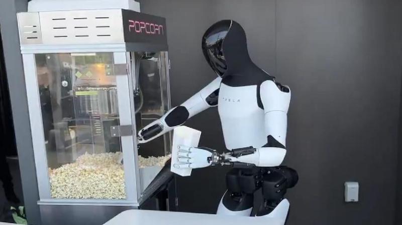 Видео дня: робот Optimus угощает детей попкорном в новом заведении Tesla's Hollywood Diner and Supercharger