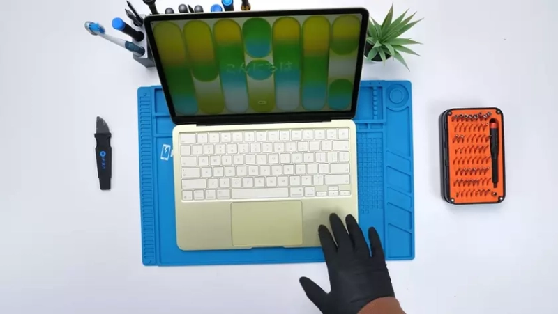 Внутренние компоненты MacBook Neo на столе для разборки