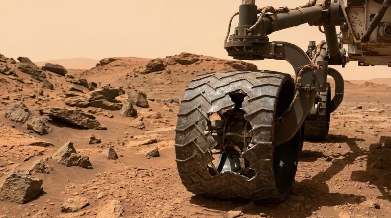 Повреждённое колесо марсохода Curiosity на фоне грунта