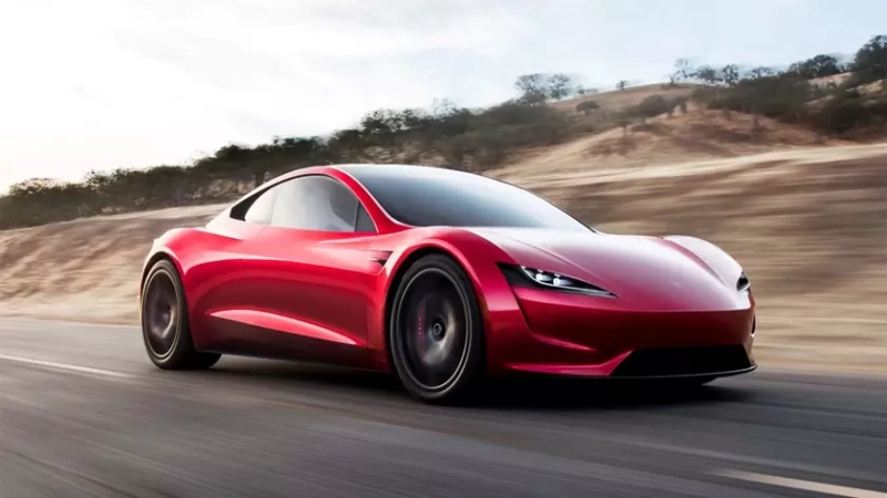 Футуристический красный Tesla Roadster на дороге